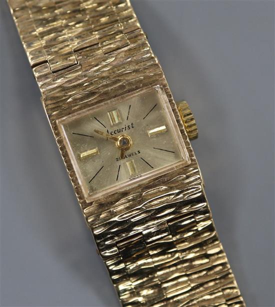 A ladys 1960s textured 9ct gold Accurist manual wind wrist watch, with spare link.